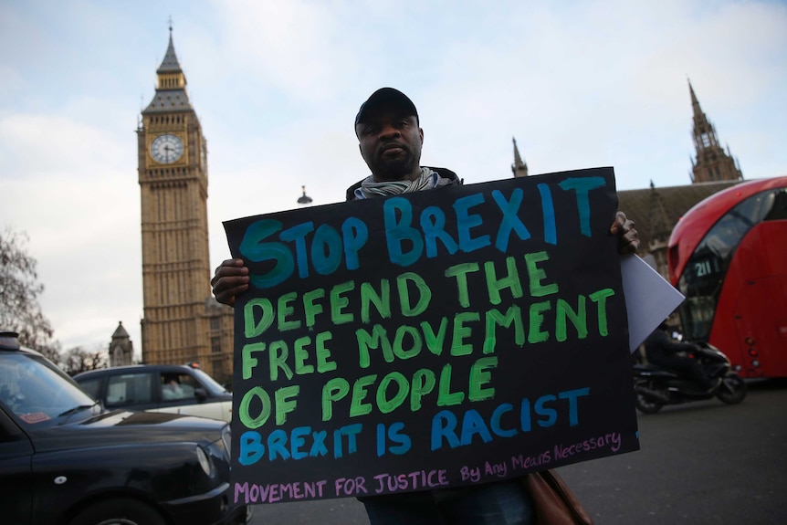 An anti-Brexit protester holds a sign outside the Houses of Parliament in London.