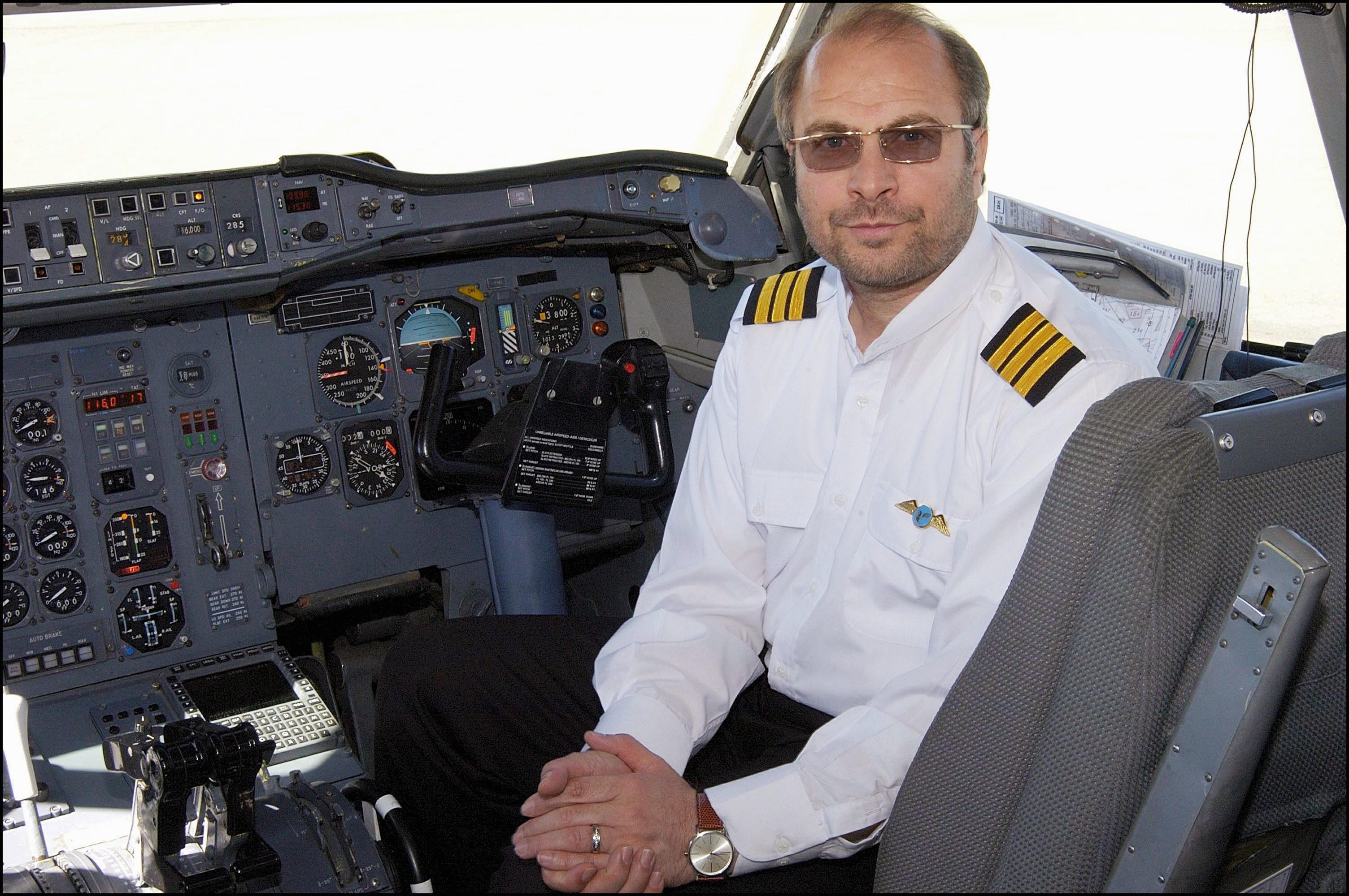 Mohammad Bagher Ghalibaf dressed in a pilot's uniform sits in the cockpit of a plane.