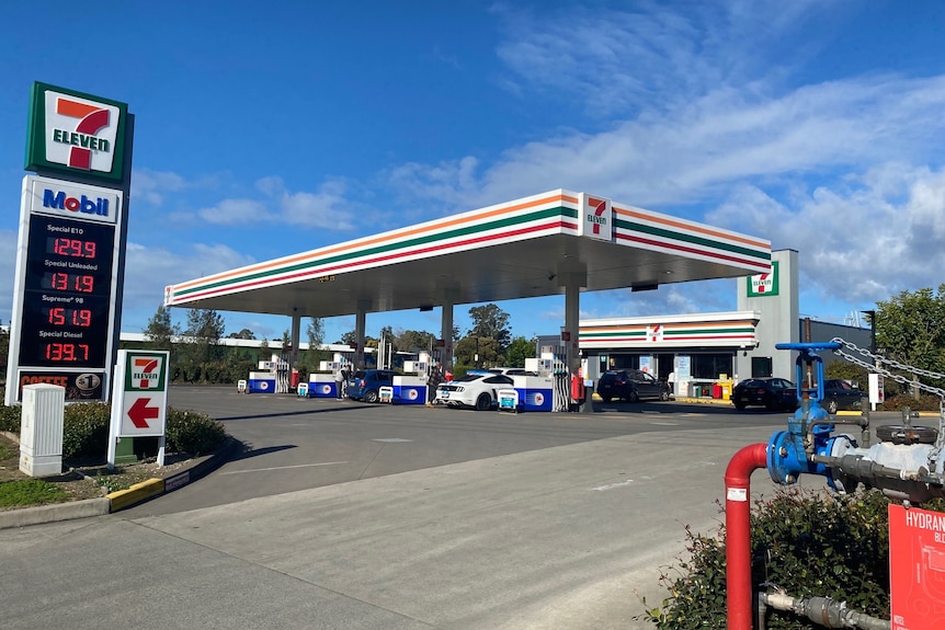 A 7-Eleven service station, with cars at the bowsers.