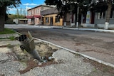 A part of a rocket sits wedged in the ground on a street in the recaptured town of Lyman