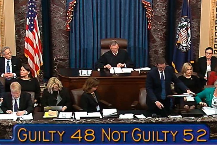 The words Guilty 48, Not Guilty 52 is displayed in front of a room of people.