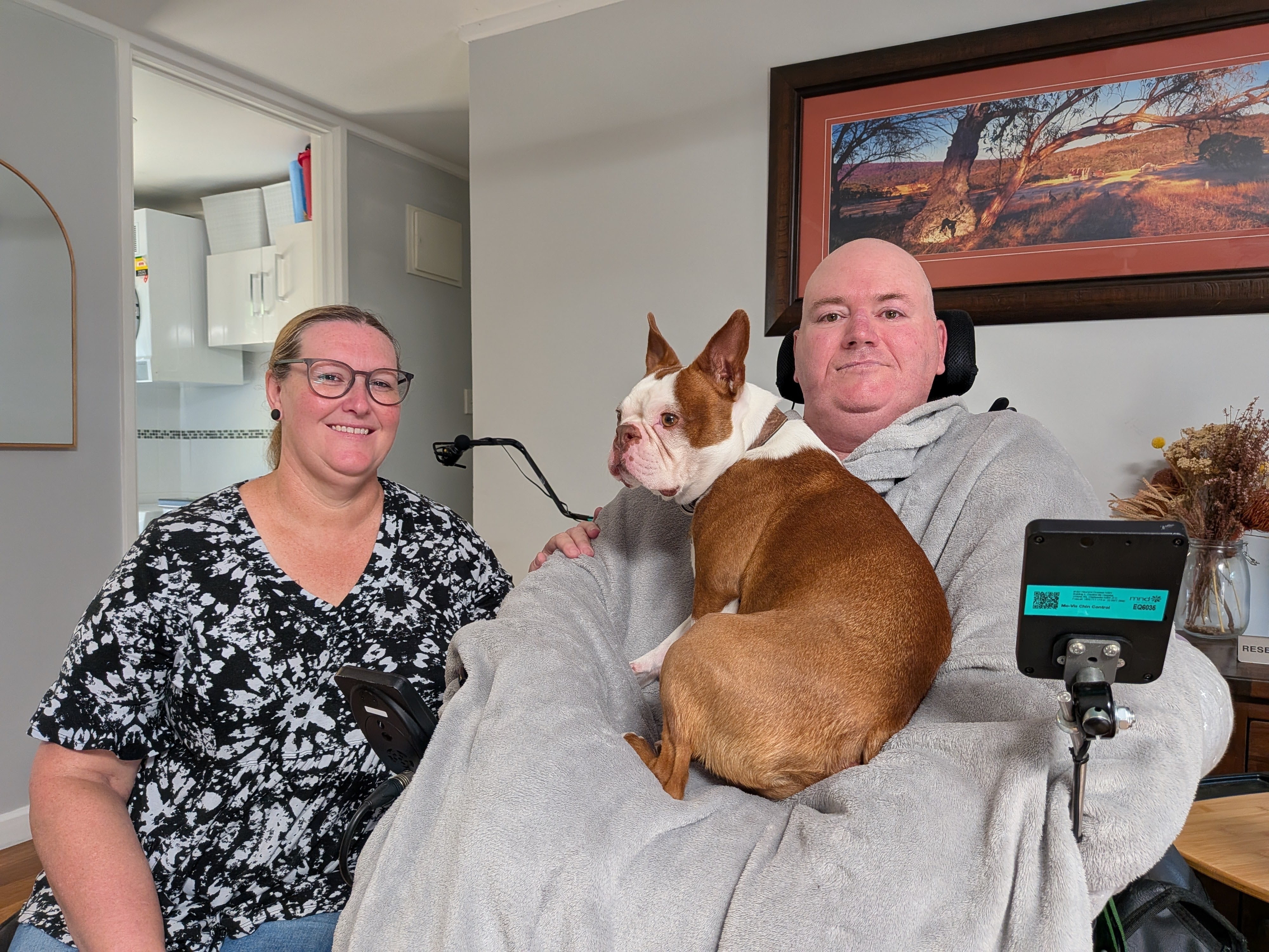 Jason Smith in wheelchair with wife Anthea and their dog at home