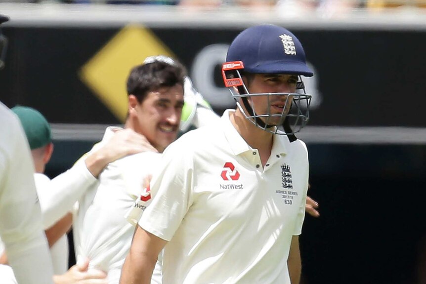 Alastair Cook walks off as Australian players celebrate in the background