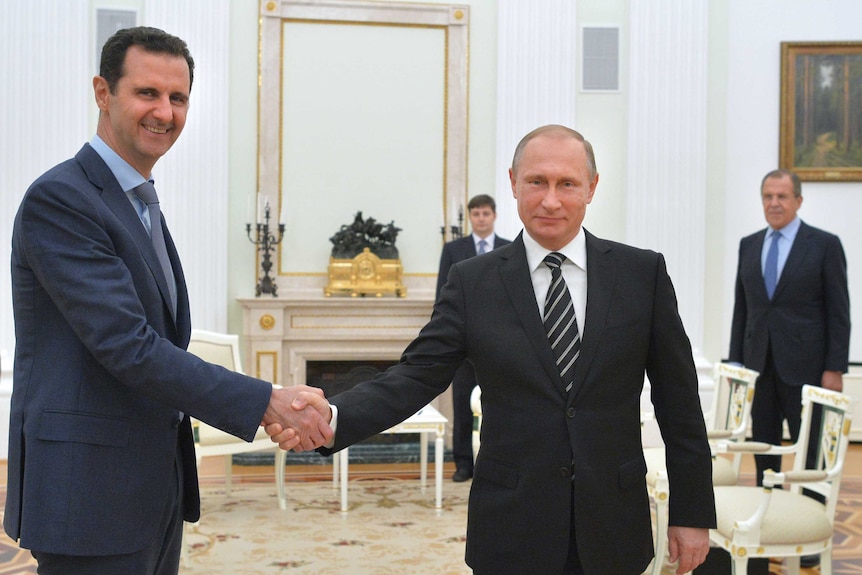 Vladimir Putin shakes hands with Bashar al-Assad