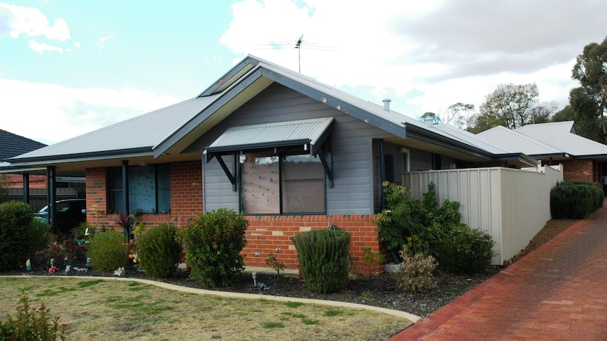 Single storey public housing units in Perth with a driveway running alongside.