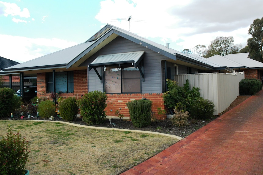 Single storey public housing units in Perth with a driveway running alongside.