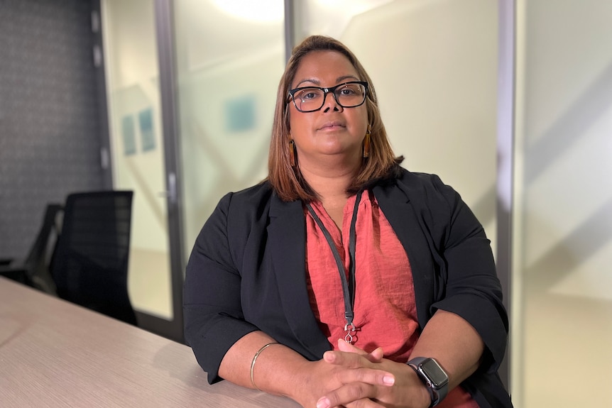 A woman sitting in a boardroom looking at the camera