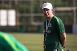 A coach in a cap stands at Socceroos training in Turkey in May 2018.