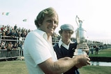 Two golfers hold up a trophy after competing at a tournament in Scotland