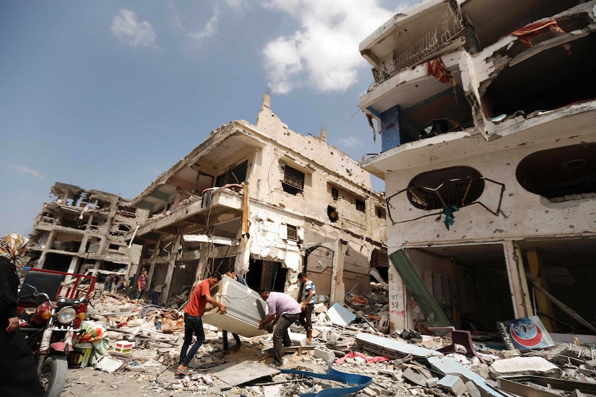 Palestinians collect items from destroyed houses in the Al-Shejaea neighbourhood of Gaza City.