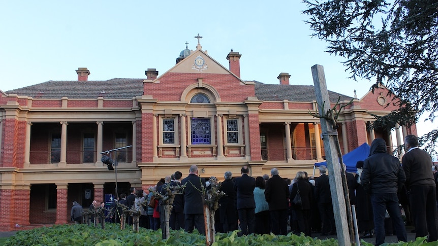 Students, staff and child sex abuse survivors gather outside St Patrick's College building in Ballarat.