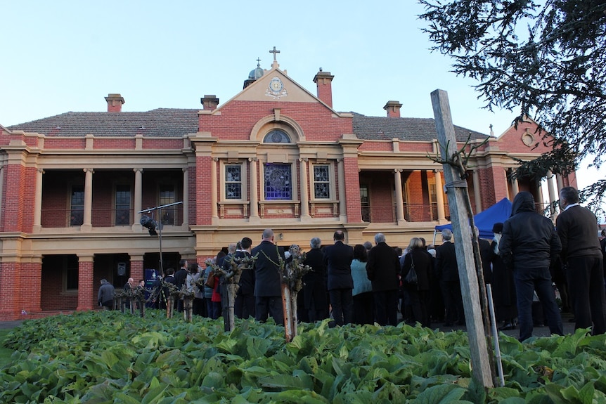 Students, staff and child sex abuse survivors gather outside St Patrick's College building in Ballarat.