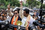 Bappi Lahiri stands in a vehicle and campaigns for a political candidate