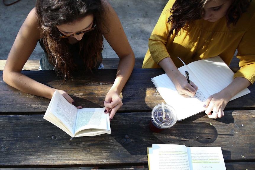 Three students at a table studying together.