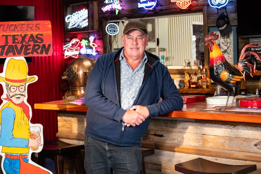 Keith Tucker leaning on drinking bar inside a shed.