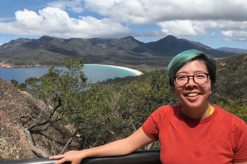 A young woman posing with mountain background.