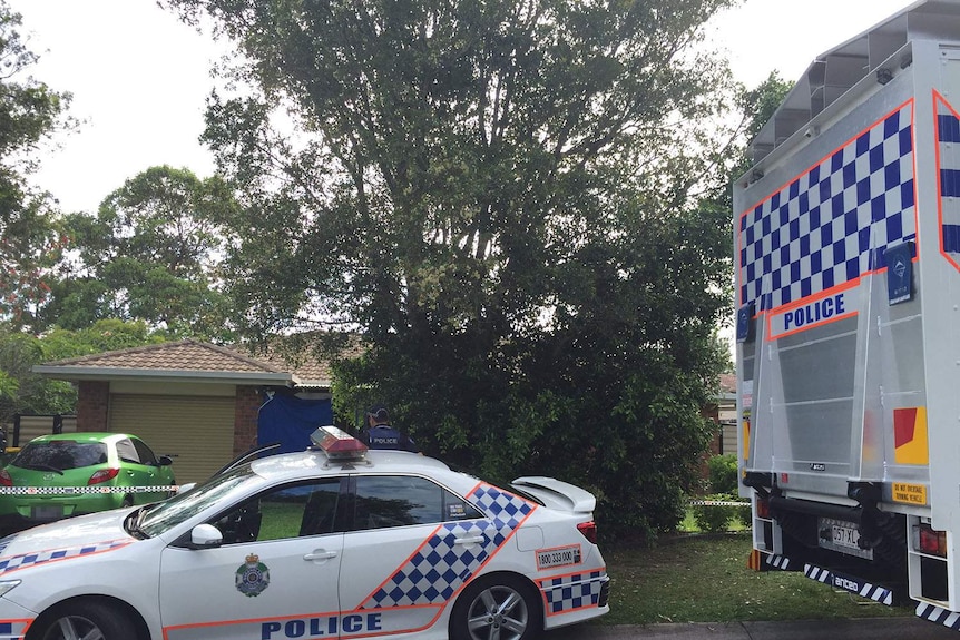 Police and forensic vehicles outside a house at Melnik Drive at Loganlea where a man was fatally stabbed.