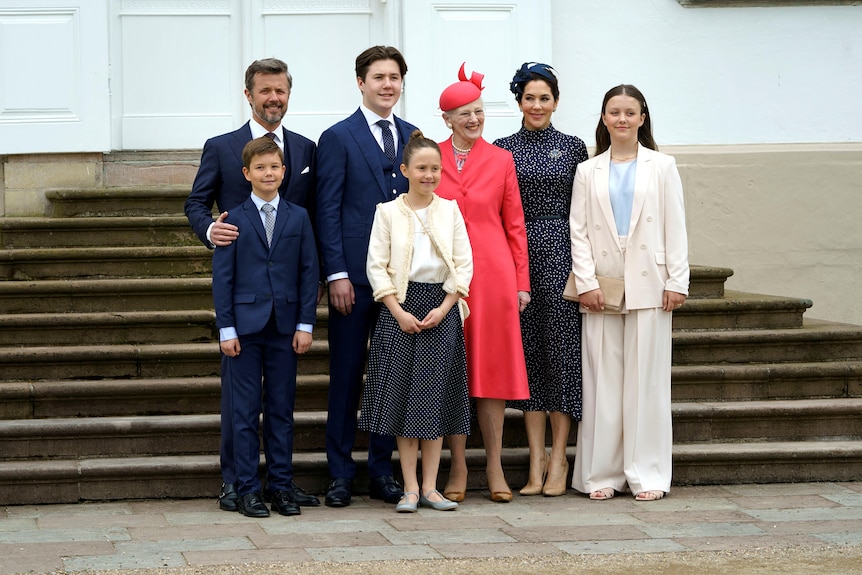 A family stand on the steps of a church in formal wear