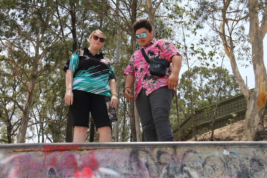Ms Smith and Mr Hall wearing sunglasses at the top of a skate ramp.