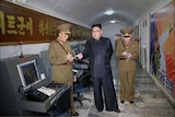 Kim Jong-un looks to be dictating to an official surrounded by old computers