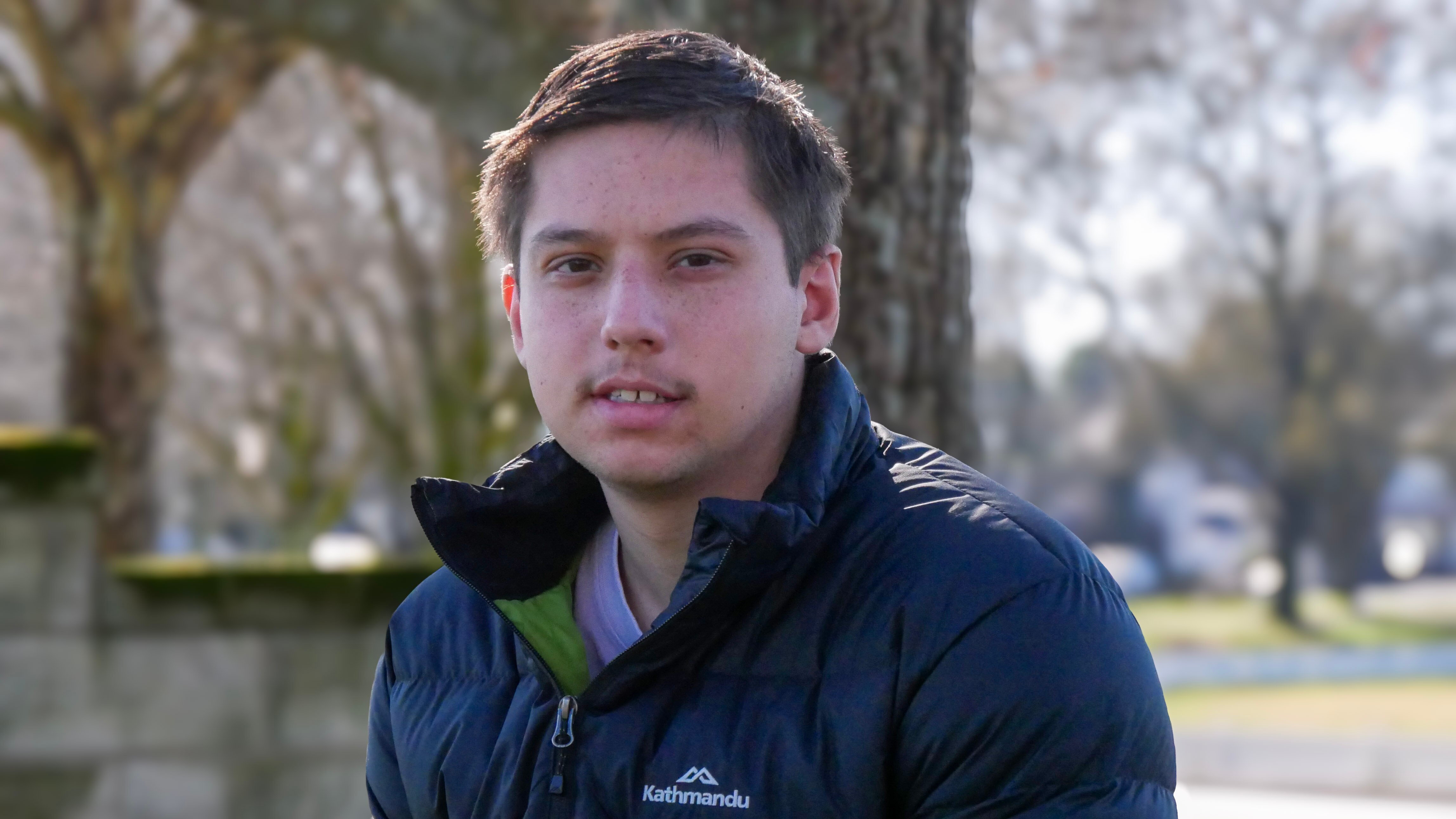 A young man smiling at the camera. 