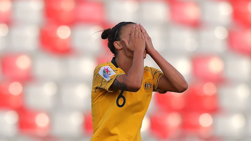 Australia soccer player puts her hands to her face after missing a shot in a game