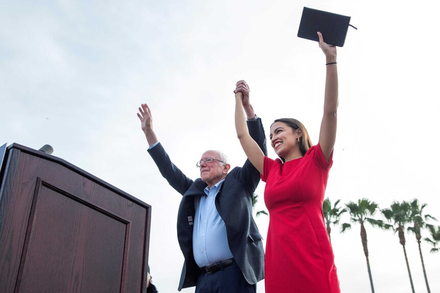 US Senator Bernie Sanders and Representative Alexandria Ocasio-Cortez cheer on stage