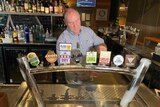 A man pulls a beer behind the bar of the Orion Hotel
