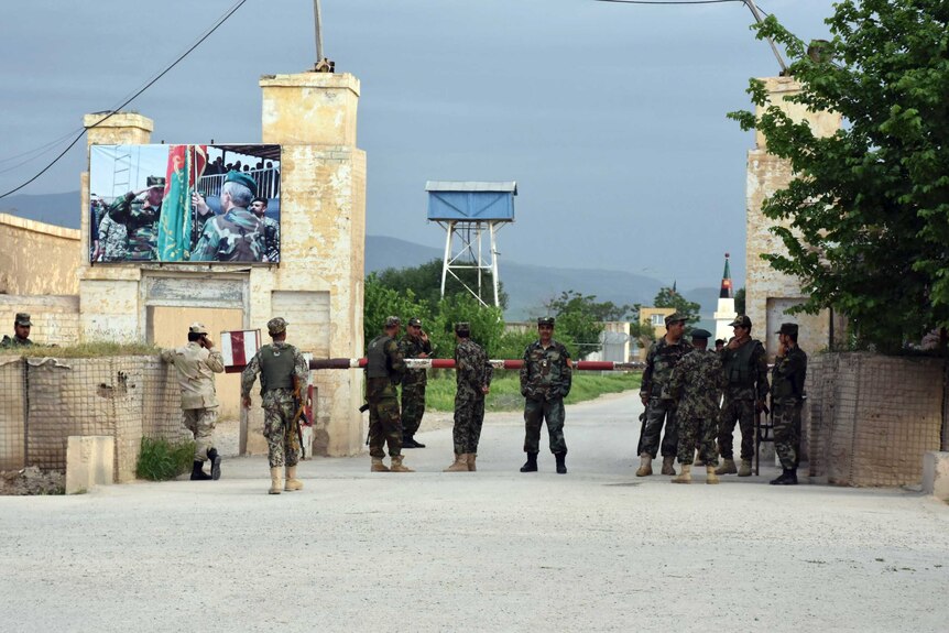 Afghan soldiers stand guard at the gate of a military compound after an attack by gunmen in Mazar-e- Sharif.