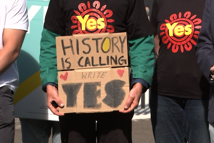 people wearing t-shirts that read yes and one person holding a placrd that read history is calling write yes