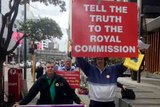Supporters of child sex abuse victims hold placards outside royal commission in Perth.jpg