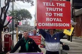 Supporters of child sex abuse victims hold placards outside royal commission in Perth.jpg