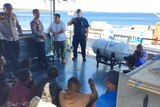 Police in Kupang, East Nusa Tenggara speak to a group of Chinese and Indonesian men