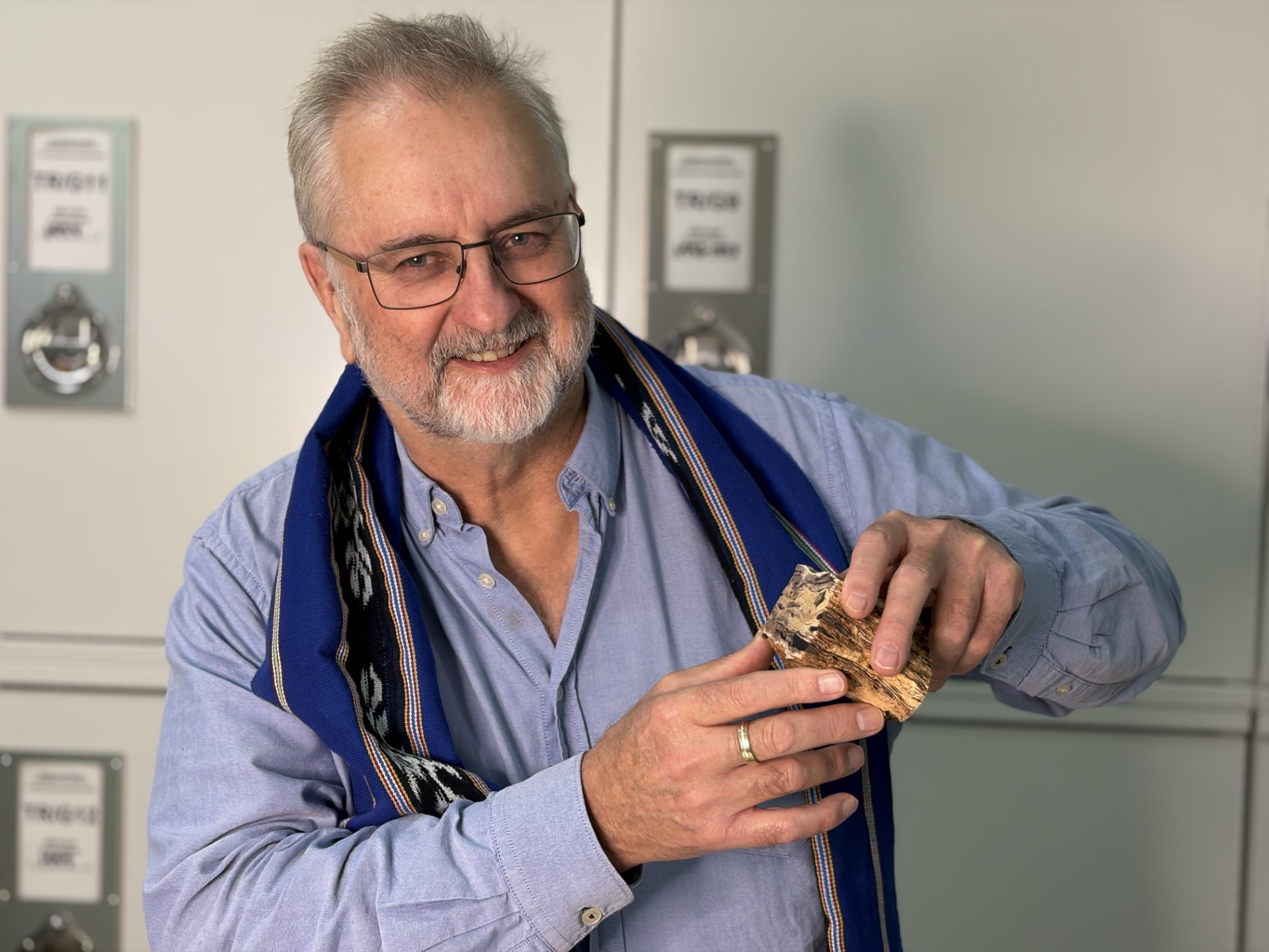 A man holding a small fossil
