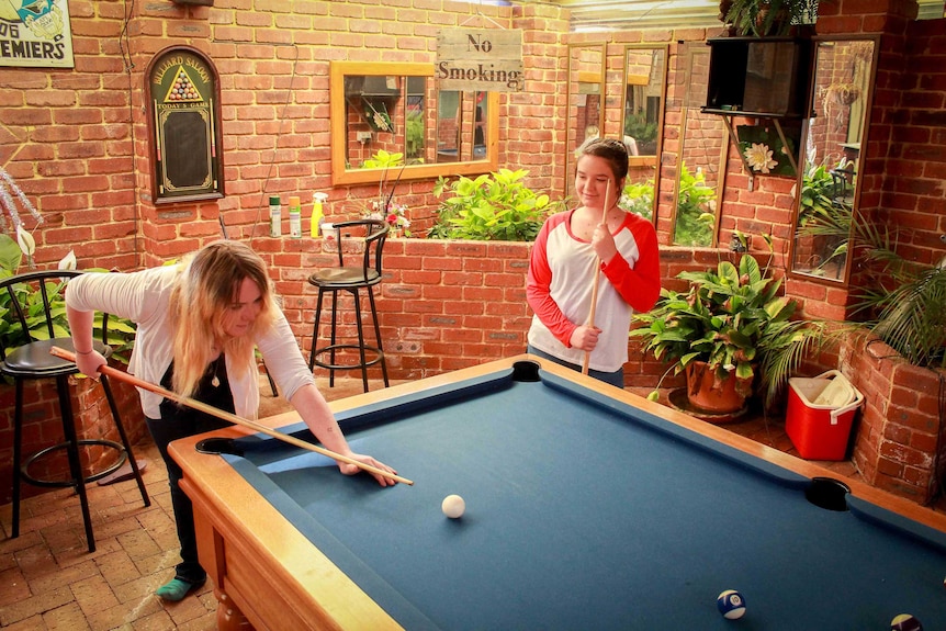 Paige and Tea Johnston playing pool at their grandparents home.