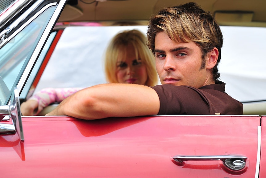 Zac Efron and Nicole Kidman sitting in a red car in The Paperboy