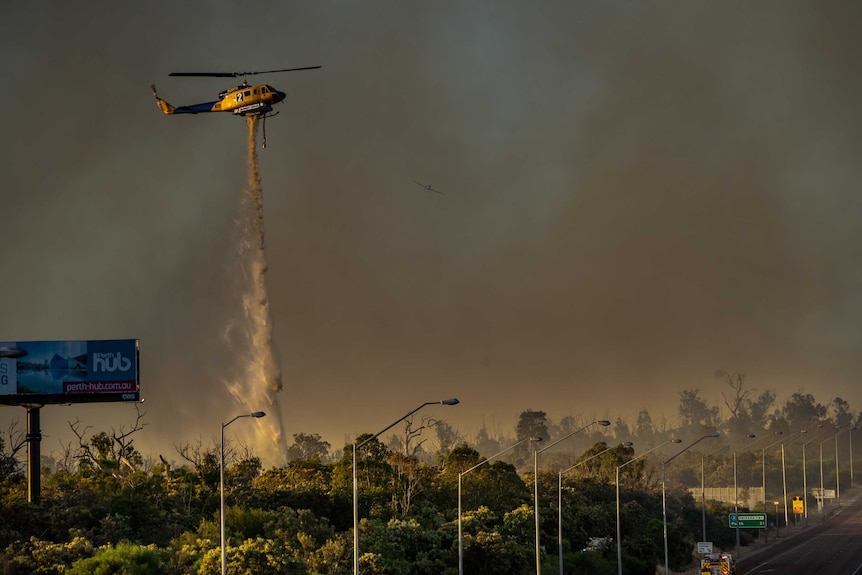 A waterbomber in action as firefighters fought to stop the Oakford fire crossing the Kwinana Freeway.