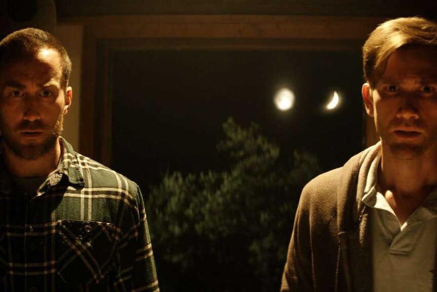 Still image of Justin Benson and Aaron Moorhead inside the doorway of a house in the night, in the 2017 film The Endless.