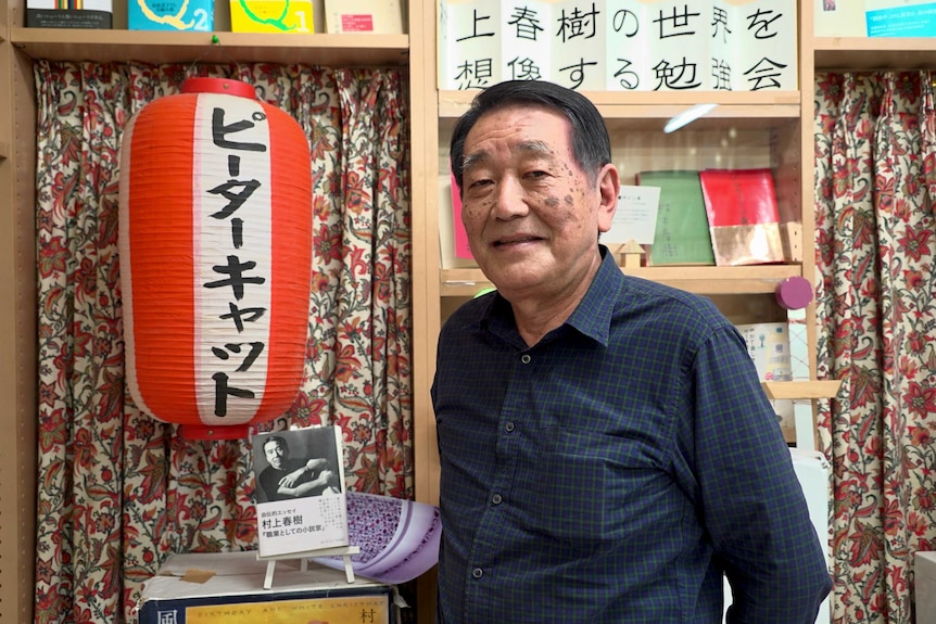 Japanese novelist Haruki Murakami stands with one of his books.