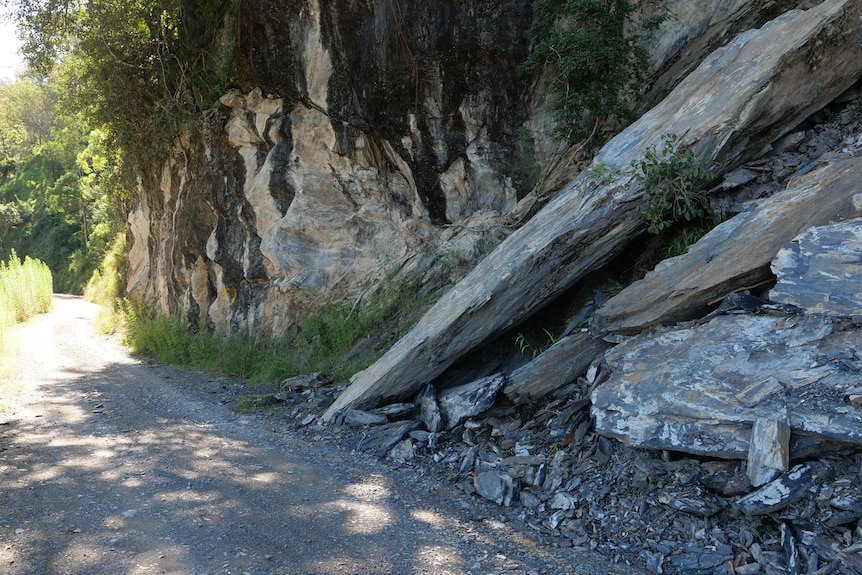 Narrow winding road with large slabs of rock on the side of the path
