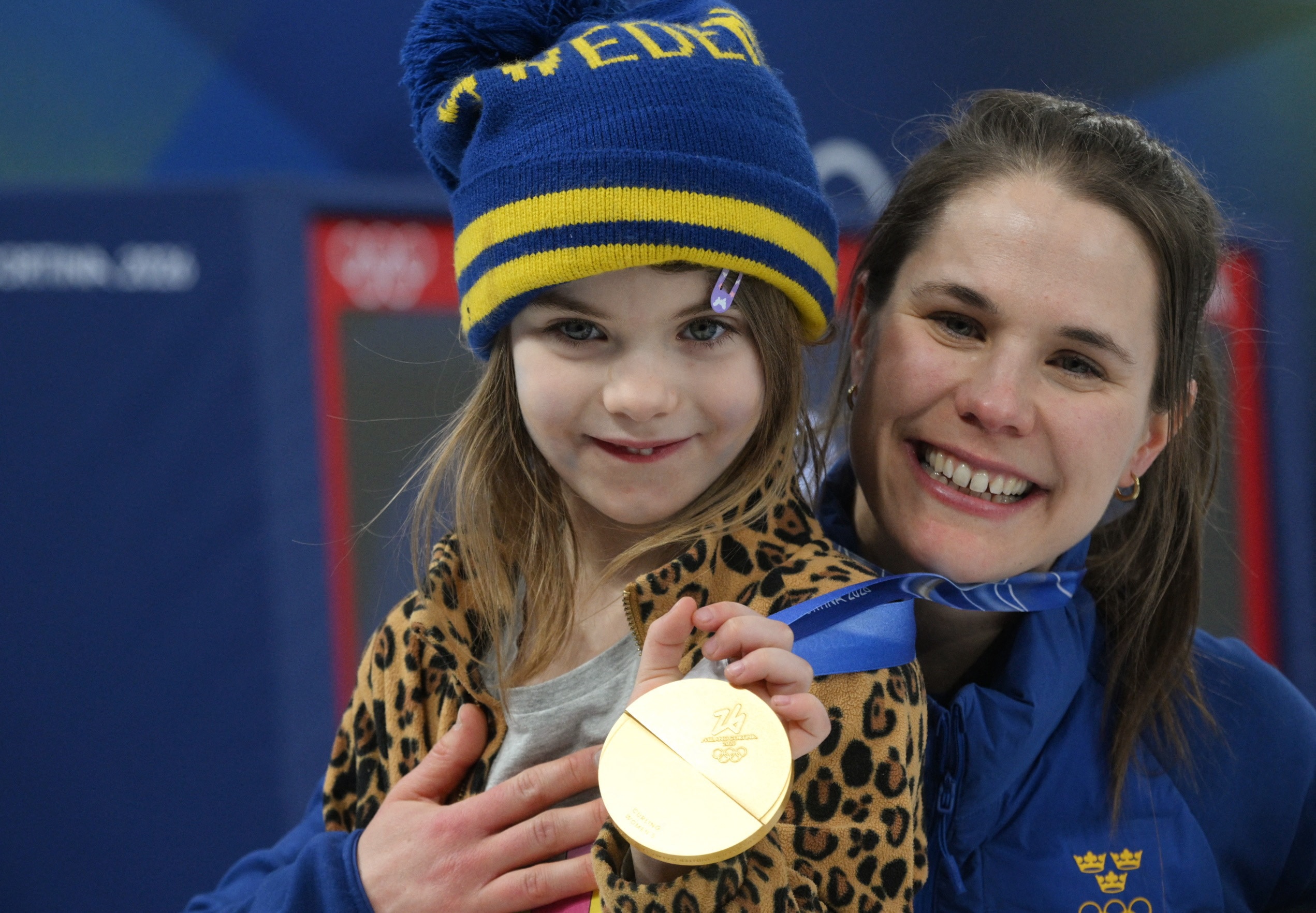 Золотая медалистка Анна Хассельборг из Швеции радуется с дочерью после церемонии победы в женском керлинге.