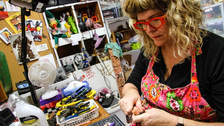 A woman in her artist studio surrounded by toys