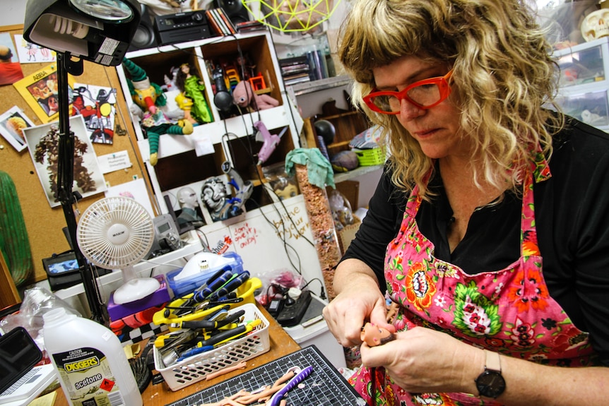 A woman in her artist studio surrounded by toys