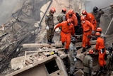 Firefighters carry the body of a victim through the debris of a collapsed building in Rio.