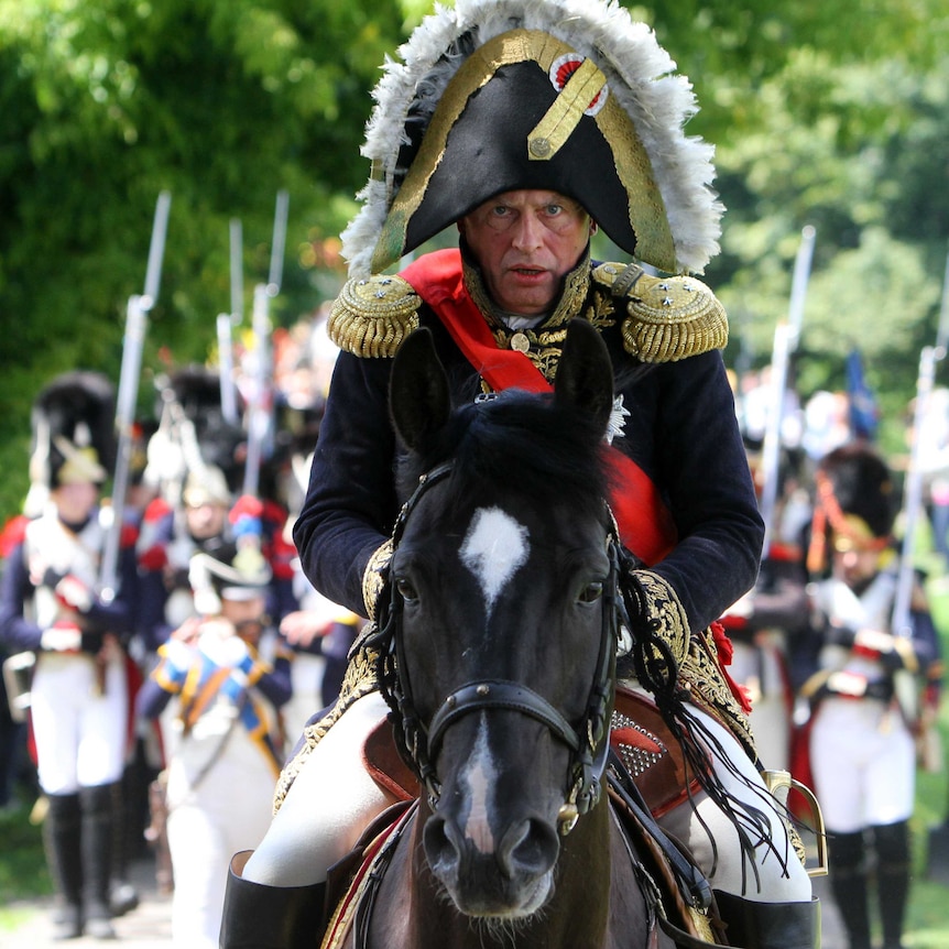 Oleg Sokolov stares straight ahead as he sits on a horse wearing a Napoleon costume.