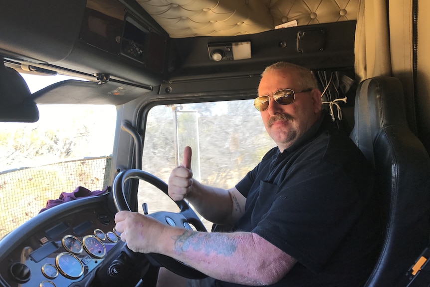 Mike in his truck, pulling a thumbs up.