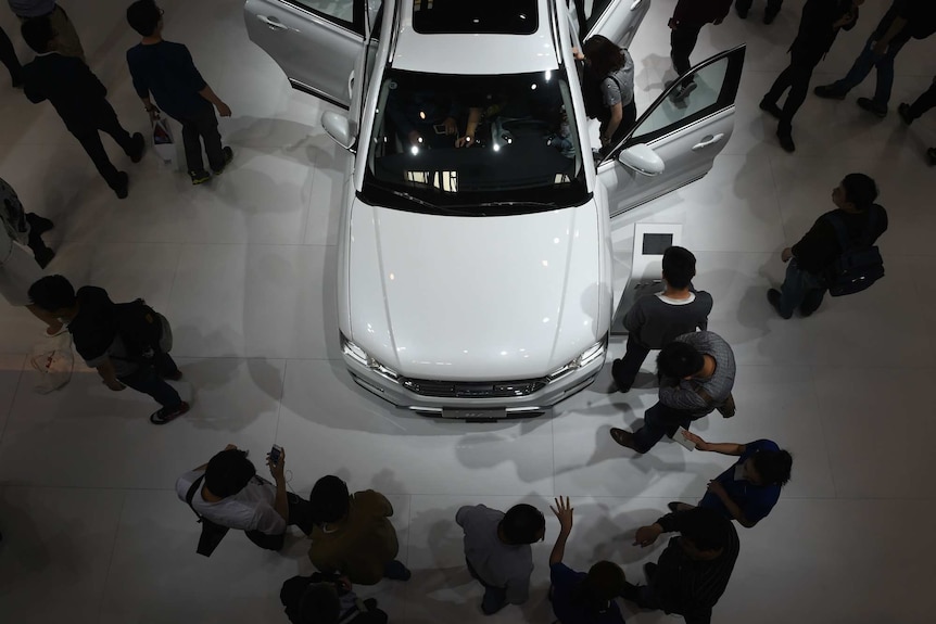 People gathered around a white SUV