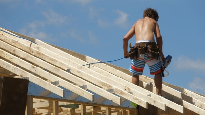 A construction worker stands on a roof on a construction site in north-west Sydney.