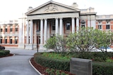 A wide shot of the front of the Supreme Court of WA with a garden bed in the foreground.