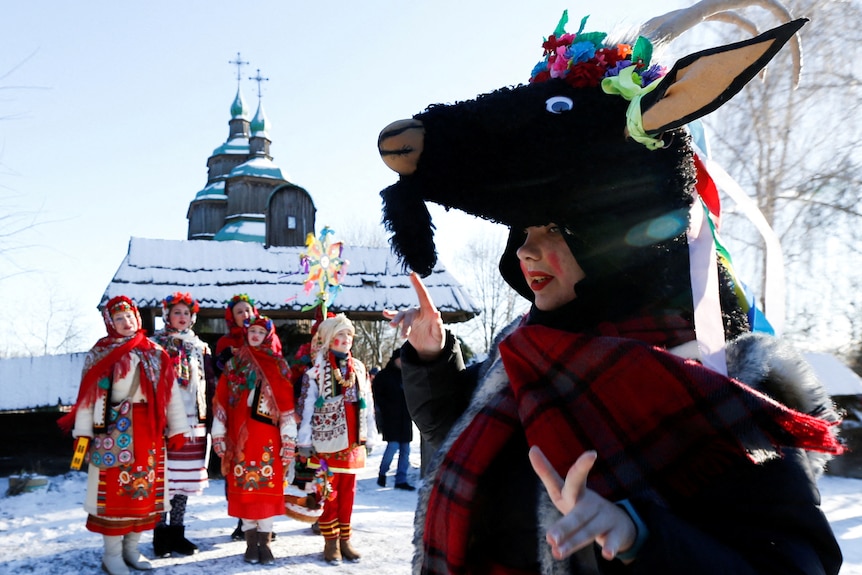 People dressed in traditional Ukrainian costumes sing Christmas carols 